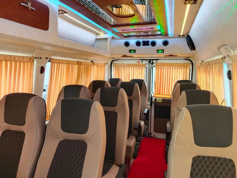 Inside a Tempo Traveller showing pushback seats used for group travel from Mangalore